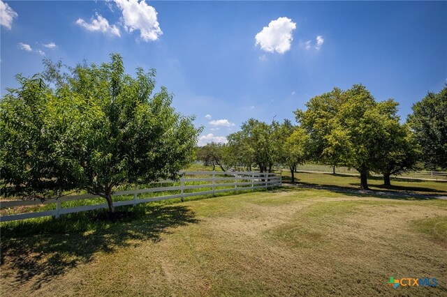 view of property's community with a rural view and a yard