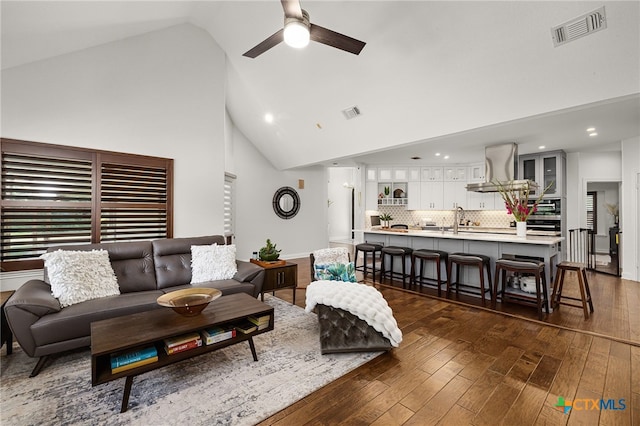 living room featuring high vaulted ceiling, dark hardwood / wood-style floors, ceiling fan, and sink