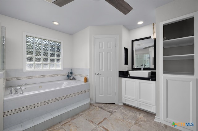 bathroom with vanity and tiled bath