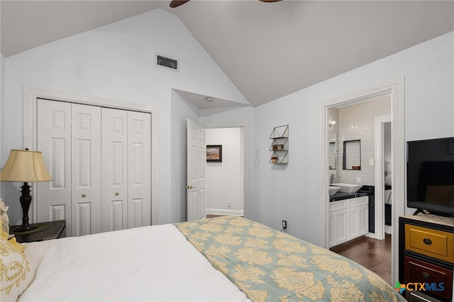 bedroom with dark hardwood / wood-style flooring, connected bathroom, high vaulted ceiling, ceiling fan, and a closet