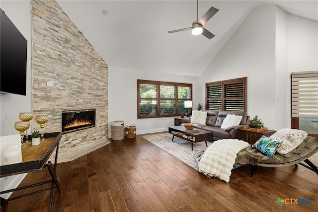 living room with dark wood-type flooring, ceiling fan, a fireplace, and high vaulted ceiling