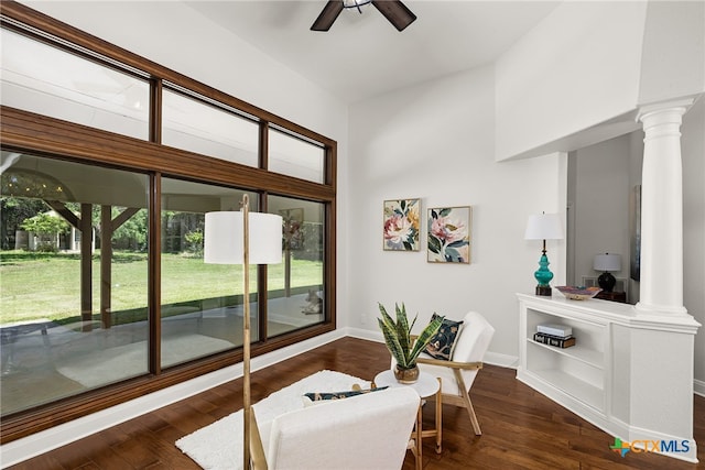 interior space featuring dark wood-type flooring, ceiling fan, and decorative columns