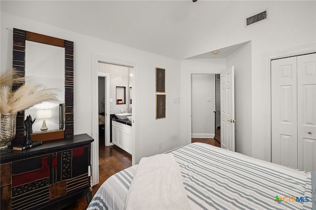 bedroom featuring sink, lofted ceiling, a closet, and dark hardwood / wood-style flooring