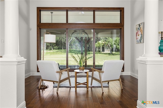 living area featuring dark hardwood / wood-style floors and decorative columns