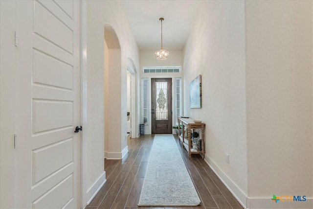 foyer with dark hardwood / wood-style floors and an inviting chandelier