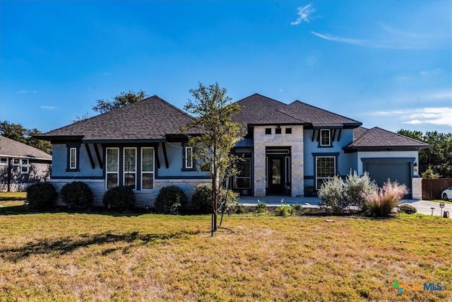 view of front of property with a garage and a front lawn