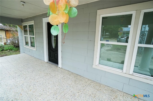 view of exterior entry with a patio