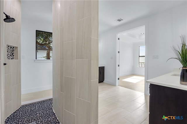 bathroom with vanity and tiled shower