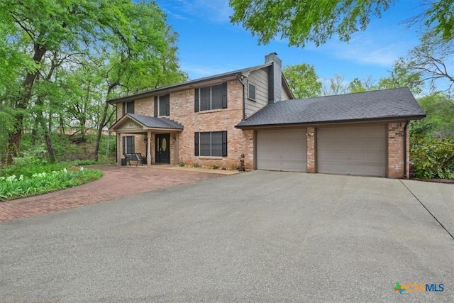 102 Elm Dr, Belton, TX 76513 - colonial house with an attached garage, a chimney, brick siding, and aphalt driveway