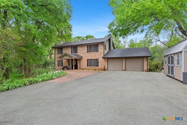 102 Elm Dr, Belton, TX 76513 - colonial-style house featuring brick siding, an attached garage, aphalt driveway, and a chimney