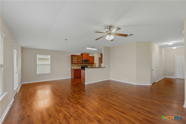 unfurnished living room featuring ceiling fan and dark hardwood / wood-style floors