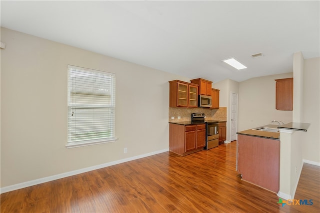 kitchen with tasteful backsplash, dark wood-type flooring, stainless steel appliances, and sink