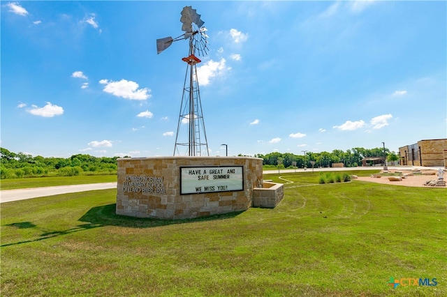 community sign featuring a yard