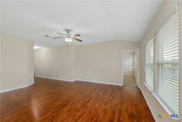 empty room with vaulted ceiling, ceiling fan, and dark hardwood / wood-style floors