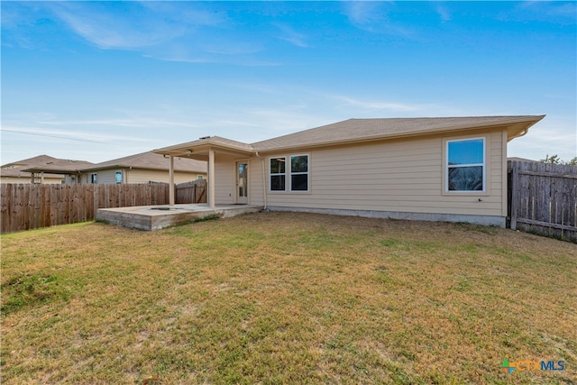 back of house featuring a lawn and a patio area