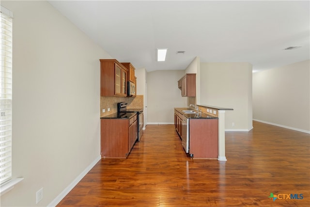 kitchen with a wealth of natural light, dark wood-type flooring, and appliances with stainless steel finishes