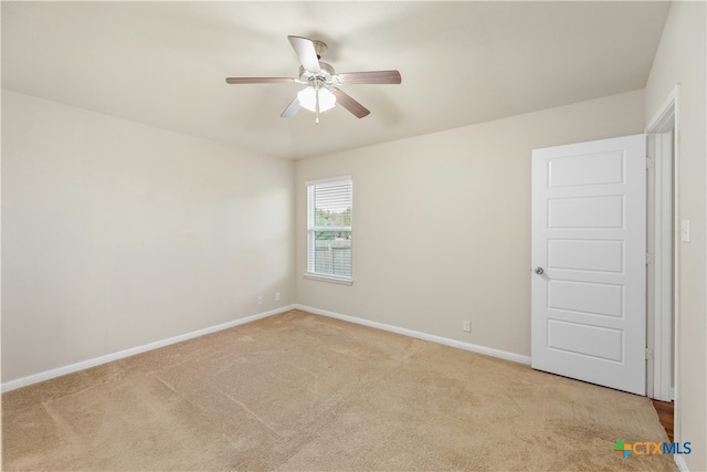 carpeted spare room with ceiling fan