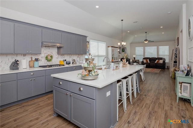 111 Dripping Spg, Victoria, TX 77904 - kitchen featuring gray cabinets, stainless steel gas stovetop, a breakfast bar area, light wood-type flooring, and a kitchen island with sink