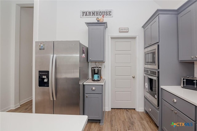111 Dripping Spg, Victoria, TX 77904 - kitchen with stainless steel appliances, gray cabinets, light wood finished floors, and light countertops