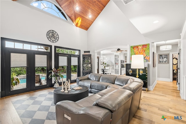 living room with high vaulted ceiling, light hardwood / wood-style flooring, and a healthy amount of sunlight