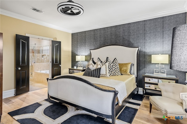 bedroom featuring light wood-type flooring, ornamental molding, and ensuite bath