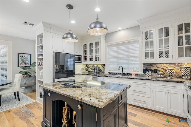 kitchen with white cabinets, light wood-type flooring, decorative backsplash, and hanging light fixtures