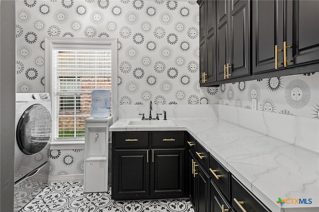 clothes washing area featuring a wealth of natural light, cabinets, sink, and washer / dryer