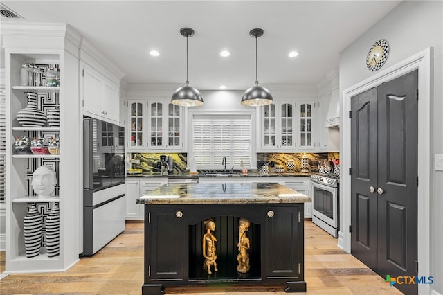 kitchen with light hardwood / wood-style floors, stainless steel appliances, a center island, white cabinets, and pendant lighting