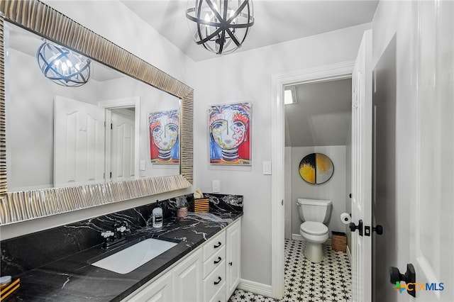 bathroom featuring tile patterned floors, vanity, toilet, and a notable chandelier