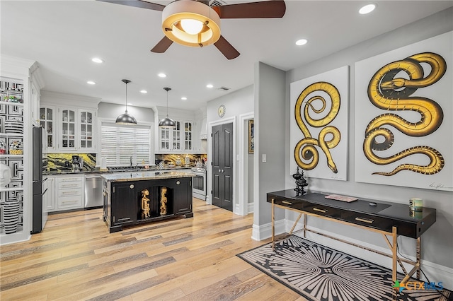 kitchen with light hardwood / wood-style flooring, white cabinetry, decorative light fixtures, and a center island