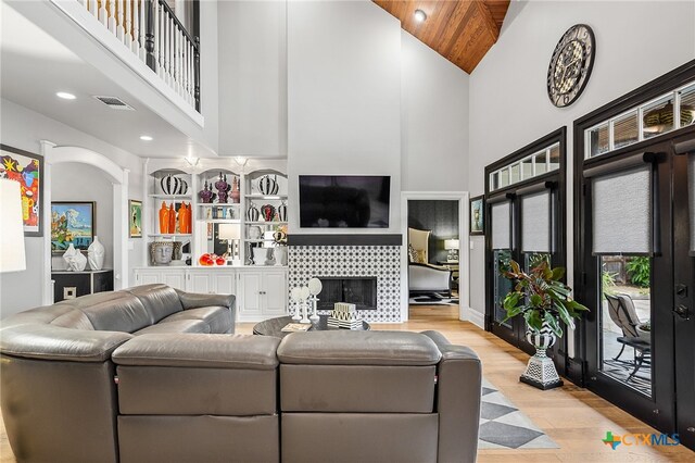 living room with wooden ceiling, light wood-type flooring, and high vaulted ceiling