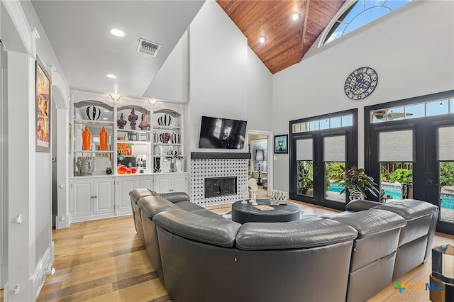 living room with high vaulted ceiling, a wealth of natural light, wooden ceiling, and light hardwood / wood-style flooring