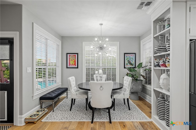 dining space with an inviting chandelier and hardwood / wood-style flooring