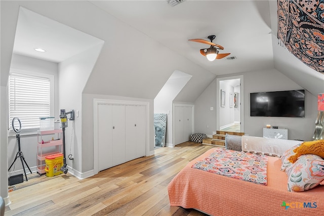 bedroom featuring lofted ceiling, connected bathroom, ceiling fan, a closet, and light hardwood / wood-style flooring