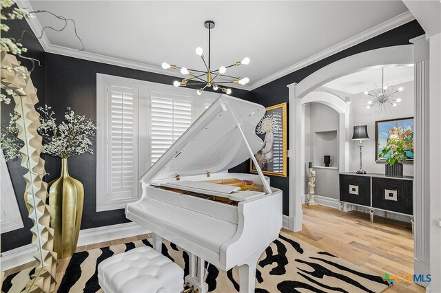 miscellaneous room with light hardwood / wood-style floors, crown molding, and an inviting chandelier