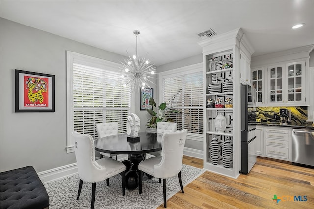 dining area featuring a chandelier and light wood-type flooring