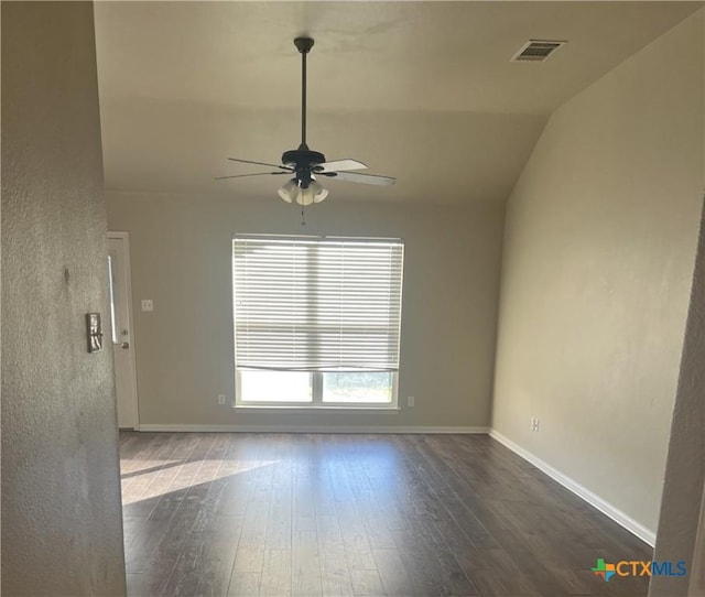 empty room with ceiling fan, dark hardwood / wood-style flooring, and vaulted ceiling