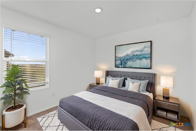 bedroom with multiple windows and light colored carpet