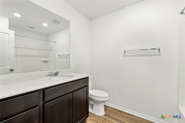 bathroom with vanity, hardwood / wood-style flooring, toilet, and walk in shower