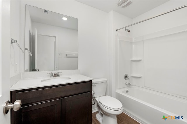 full bathroom with hardwood / wood-style flooring, toilet, vanity, and washtub / shower combination