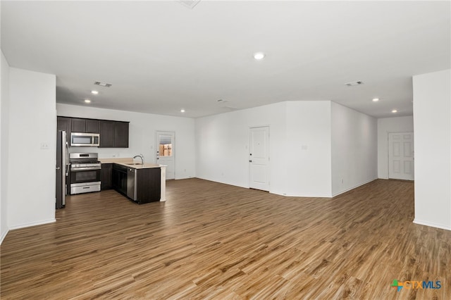 unfurnished living room featuring hardwood / wood-style flooring and sink