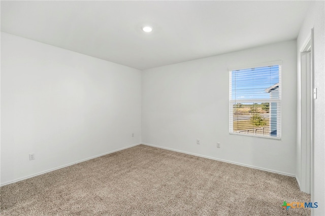 spare room featuring light colored carpet