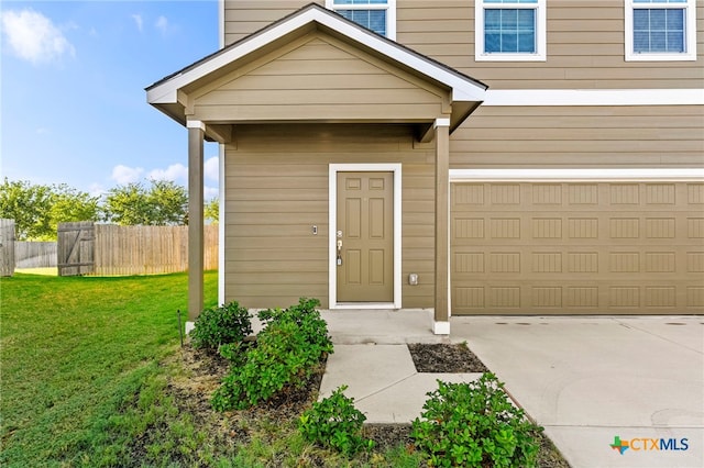 doorway to property featuring a garage and a lawn