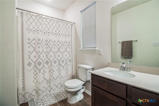 bathroom featuring hardwood / wood-style flooring, vanity, toilet, and curtained shower