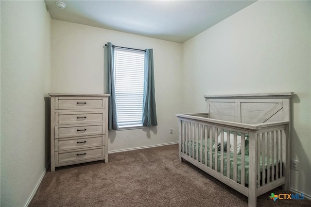 bedroom featuring dark carpet and a crib