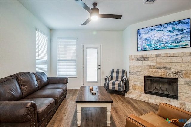 living room with hardwood / wood-style flooring, ceiling fan, and a fireplace