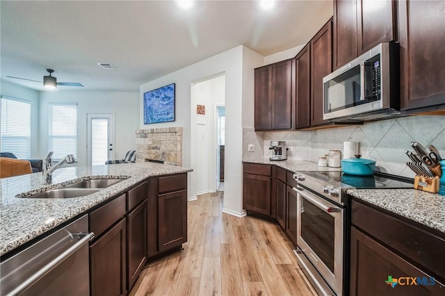 kitchen with sink, ceiling fan, appliances with stainless steel finishes, dark brown cabinets, and light wood-type flooring