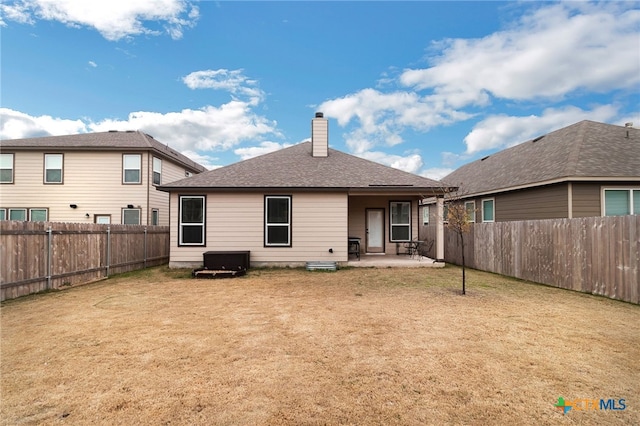 back of house featuring a patio and a lawn