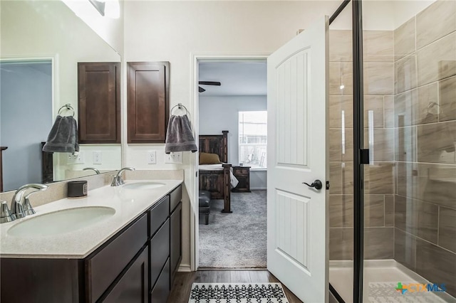 bathroom featuring hardwood / wood-style flooring, vanity, and a shower with door