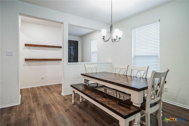 dining area with dark hardwood / wood-style floors and a notable chandelier